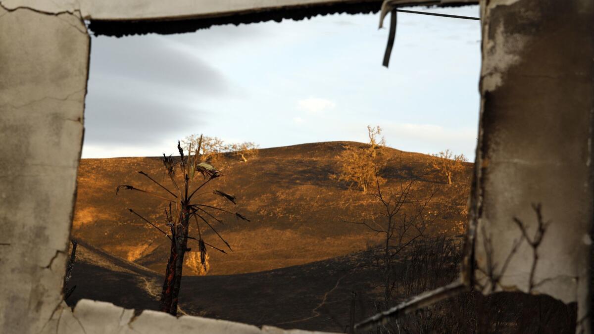 The charred hills of Calabasas are seen through a burned-out structure after the Woolsey fire.