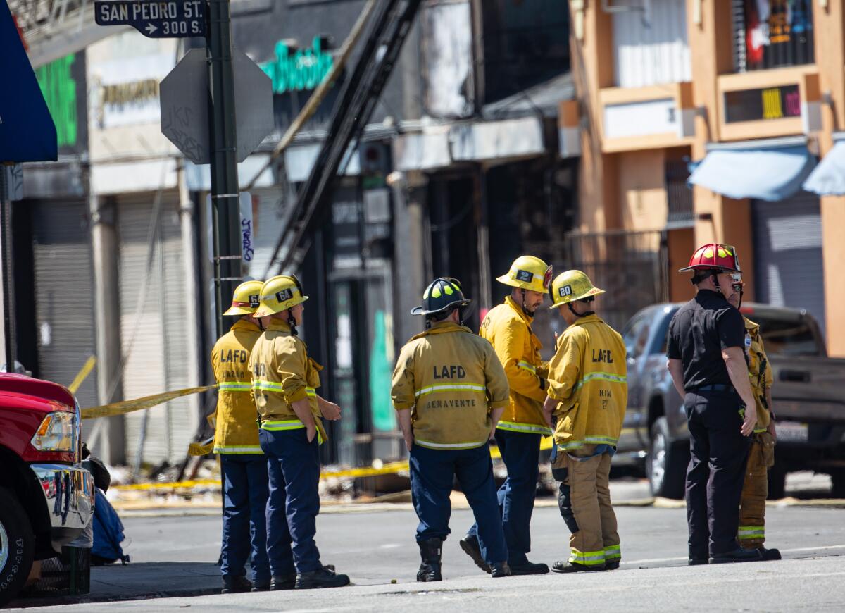 Members of the Los Angeles Fire Department standing in a street in downtown L.A.