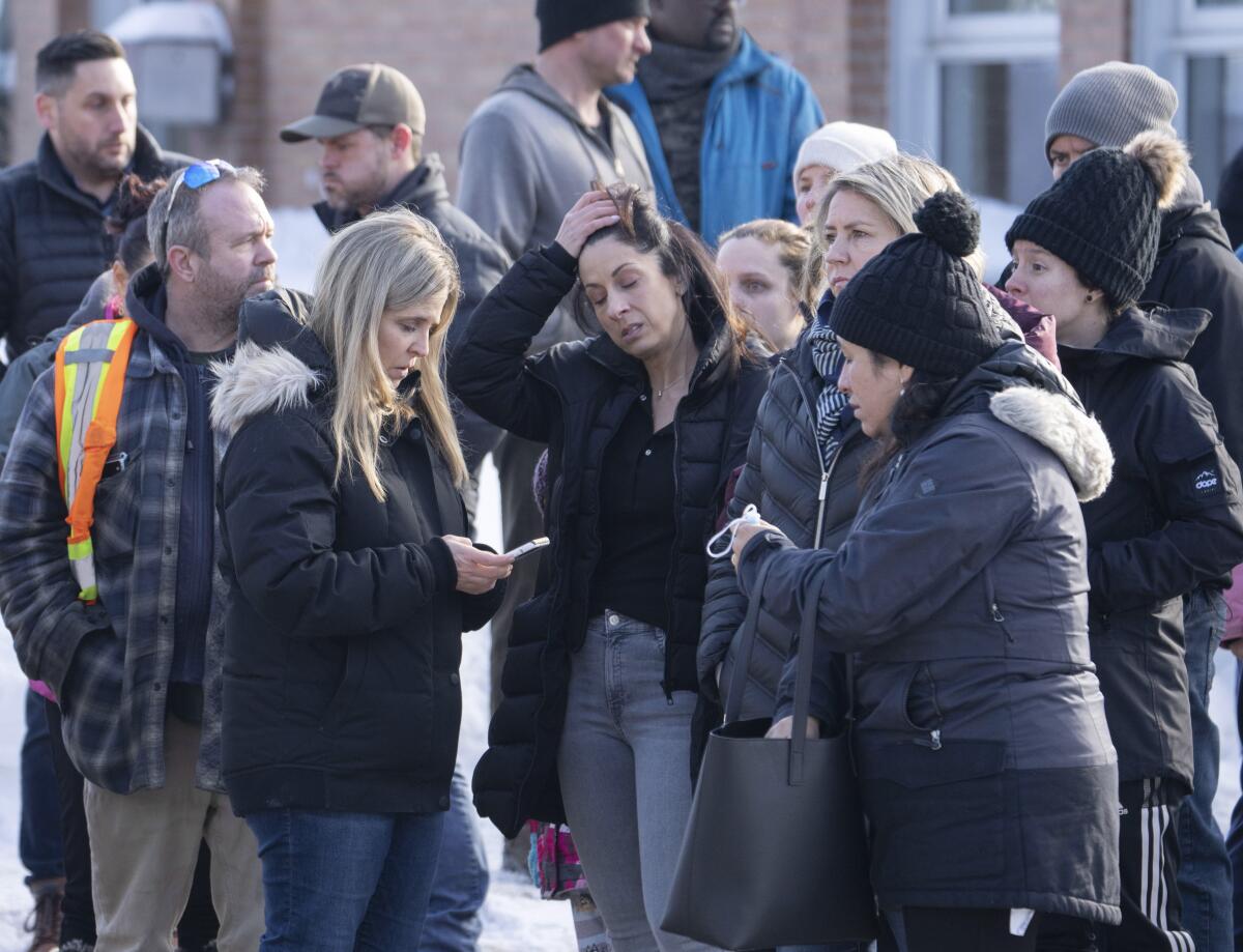 Parents wait for news after a bus crashed into a daycare centre in Laval, Quebec, on Wednesday, Feb. 8, 2023. (Ryan Remiorz/The Canadian Press via AP)