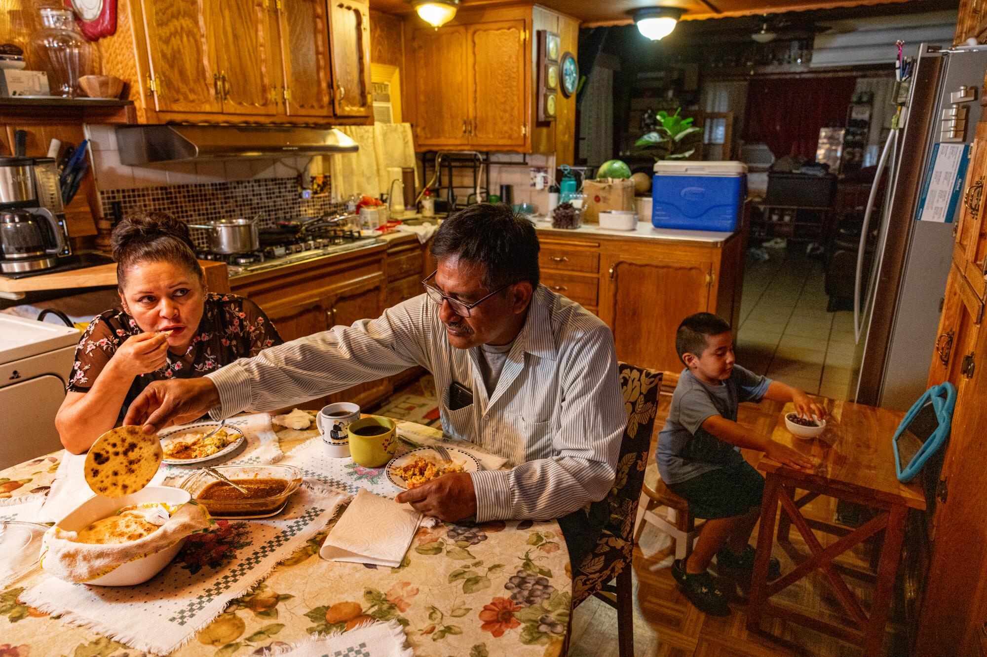 Maria Del Pilar Barradas-Medel, left, and Alejandro Medel and 4-year-old Angelo have breakfast 