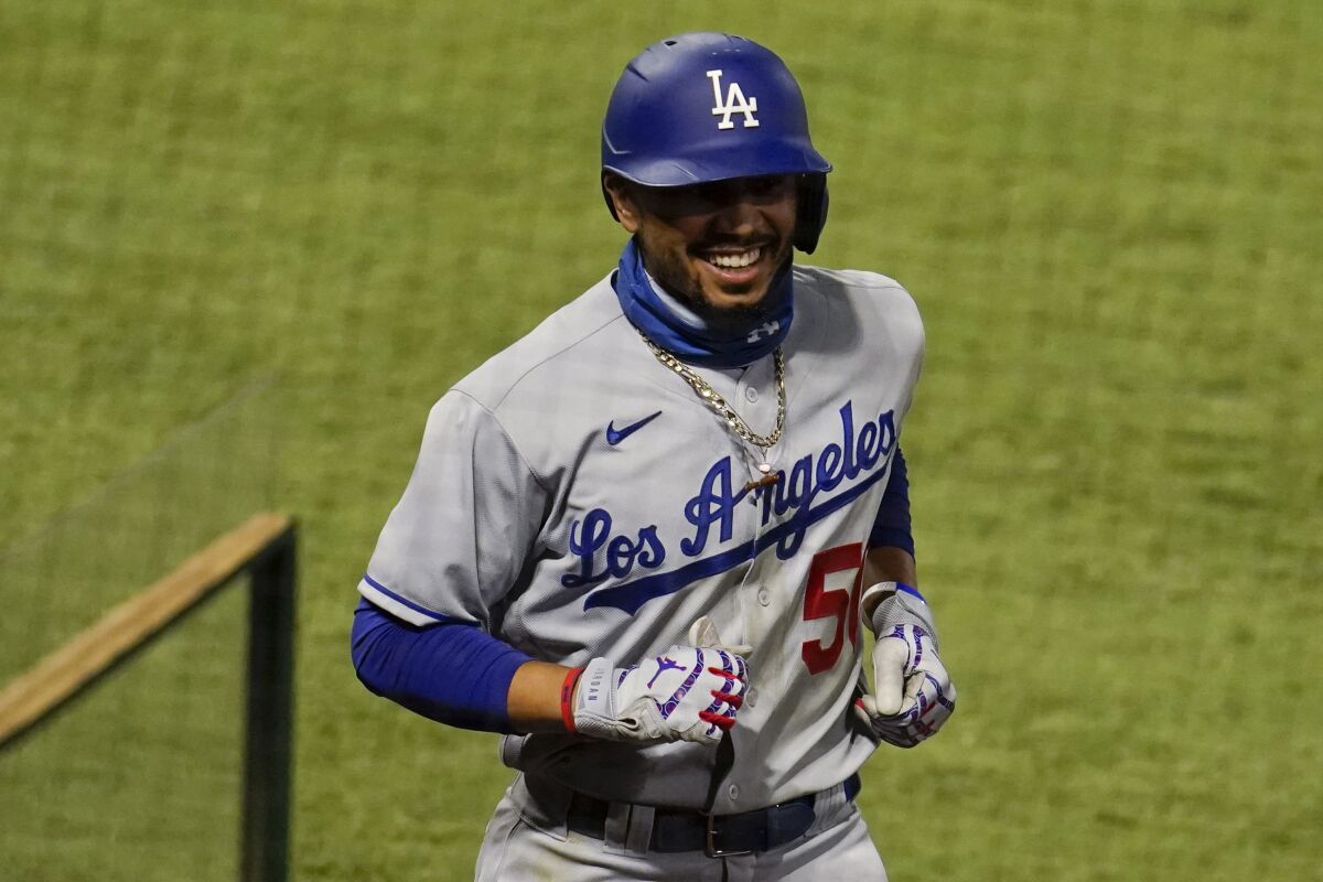 Dodgers' Mookie Betts smiles as he walks back to the dugout after hitting a solo home run. 