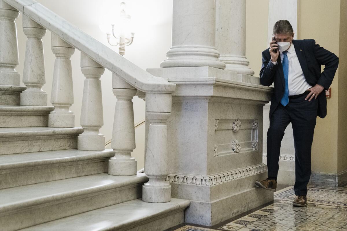 Sen. Joe Manchin III stands in a hallway just outside the Senate Chamber.