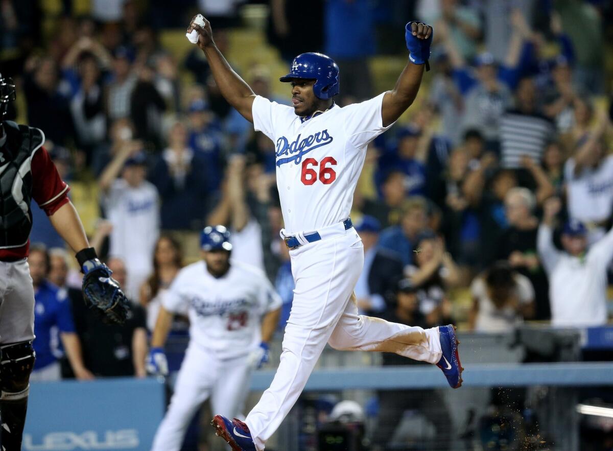 Dodgers outfielder Yasiel Puig celebrates as he scores the winning run Wednesday night against Arizona.
