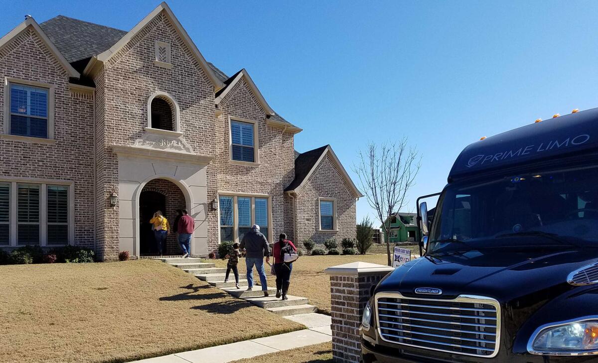 Californian families leave a bus to tour one of several north Texas homes Saturday