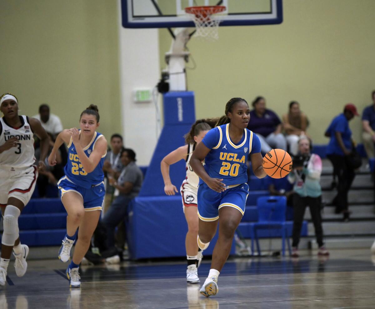 UCLA's Charisma Osborne dribbles the ball up court.