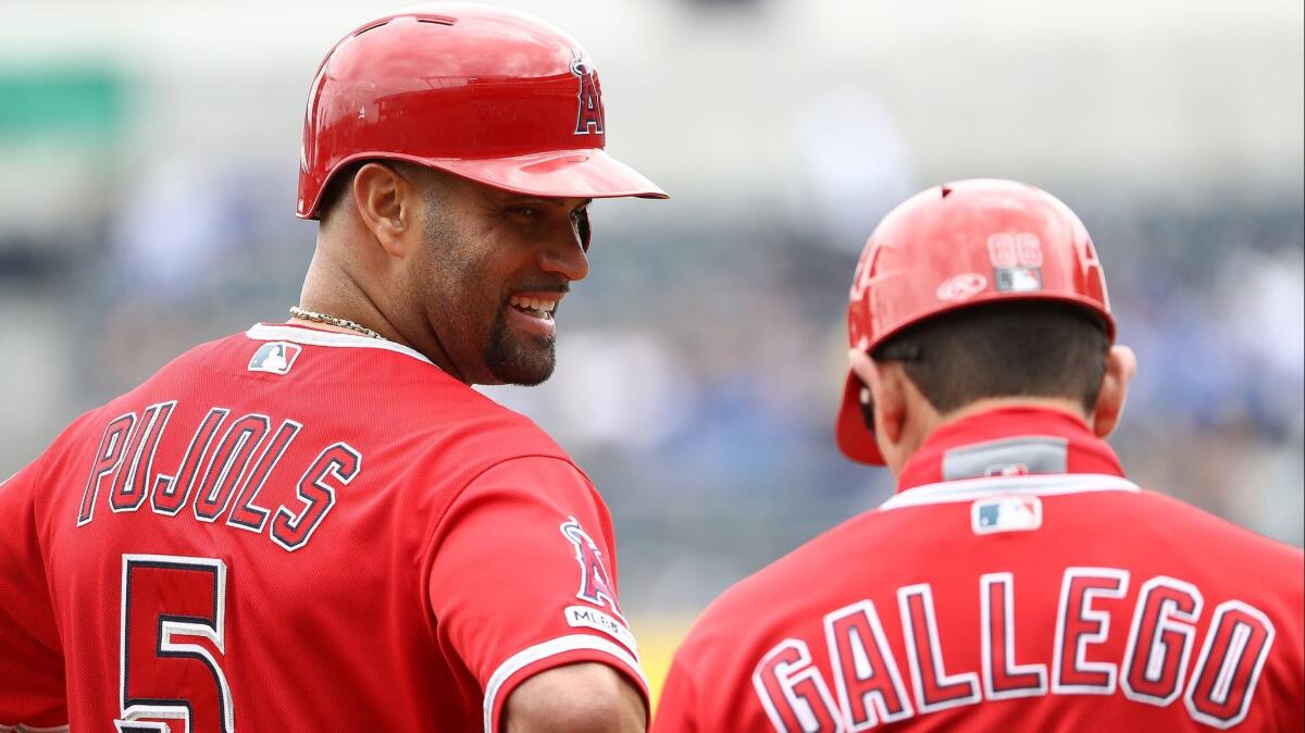 Angels slugger Albert Pujols speaks with with third-base coach Mike Gallego after driving in two runs against the Kansas City Royals on April 28.