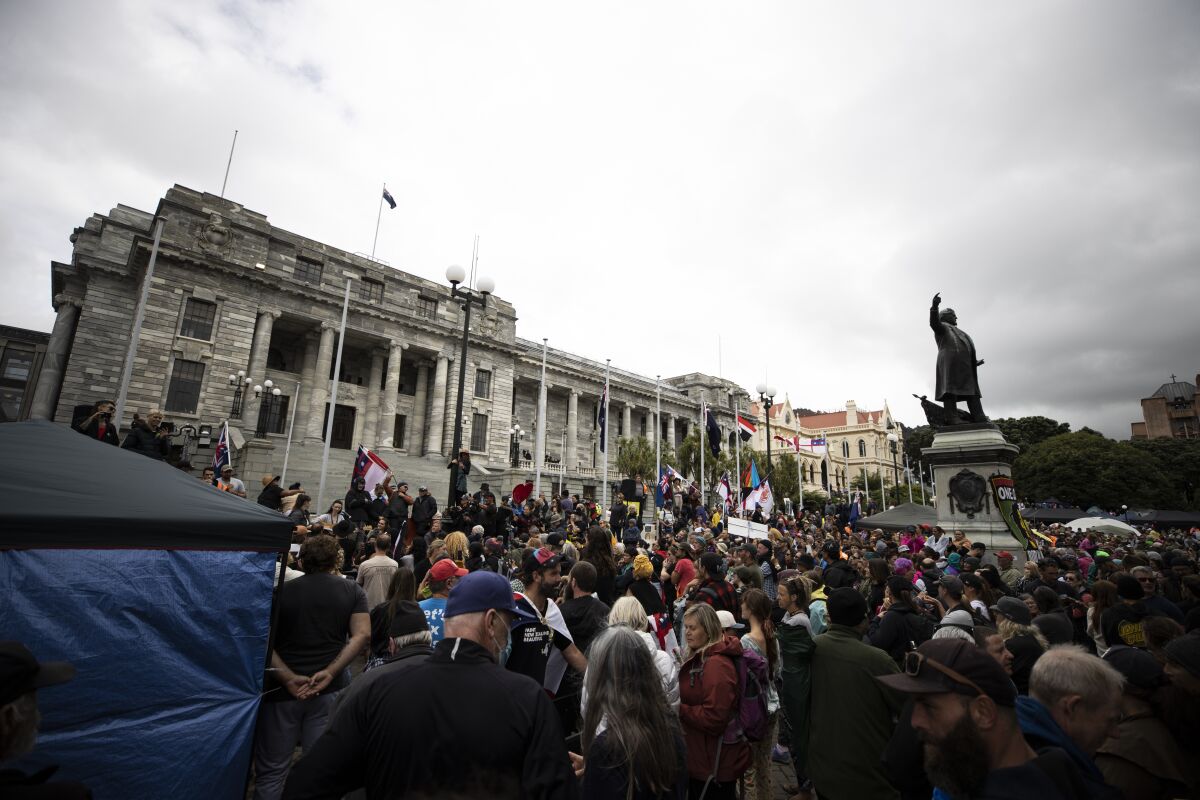 People who oppose vaccine mandates protest at Parliament in Wellington, New Zealand Monday, Feb. 14, 2022. The protesters are not planning to leave any time soon after they drove in convoys from around the country nearly a week ago, setting up tents on Parliament's grounds and blocking surrounding streets with their cars and trucks. (George Heard/New Zealand Herald via AP)