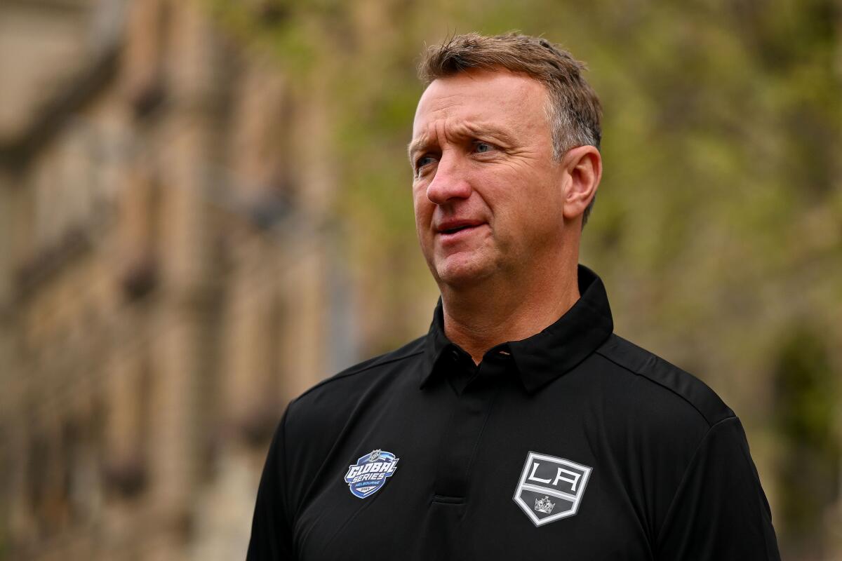 Kings general manager Rob Blake stands on a street wearing a team shirt during the team's visit to Australia.