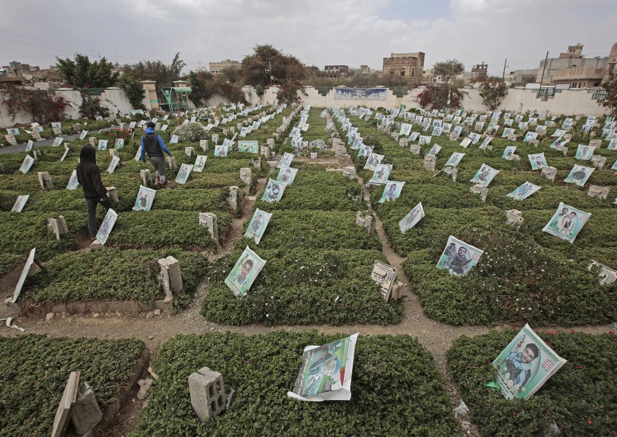 Yemeni men walk amid the graves of Houthi fighters who were killed during recent fighting, at a cemetery in Sanaa, Yemen, Tuesday, Mar. 2, 2021. (AP Photo/Hani Mohammed)