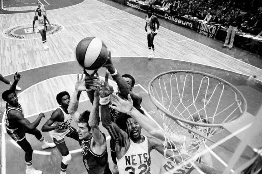 FILE - Denver Nuggets' Bobby Jones, second left, Nets' Julius Erving, fourth left, and New York Nets' Jim Eakins, right, battle for a rebound during the ABA championship playoff game at the Nassau Coliseum in Uniondale, N.Y., on May 14, 1976. The Denver Nuggets are the last of the four ABA teams that merged with the NBA to reach the Finals and is stirring up fond memories of the defunct league. (AP Photo/Richard Drew, File)