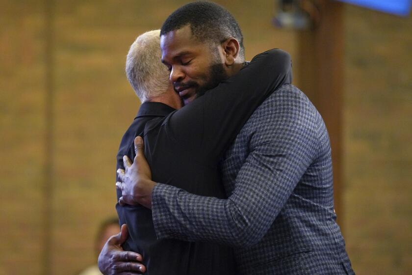 Carl Ruby, pastor de la iglesia Central Christian, abraza a Lindsay Aime durante el servicio, el domingo 15 de septiembre de 2024, en Springfield, Ohio. (AP Foto/Jessie Wardarski)