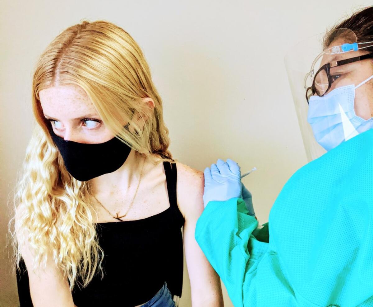 Calabasas basketball player Kearston Stepenosky receives a shot from a health worker.