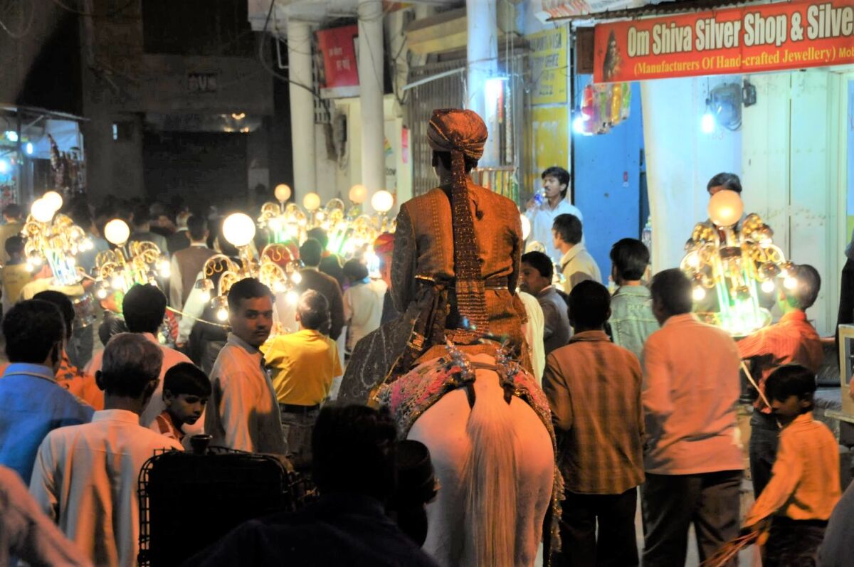 A groom rides a horse during a baraat wedding procession in Pushkar, Rajasthan, India.