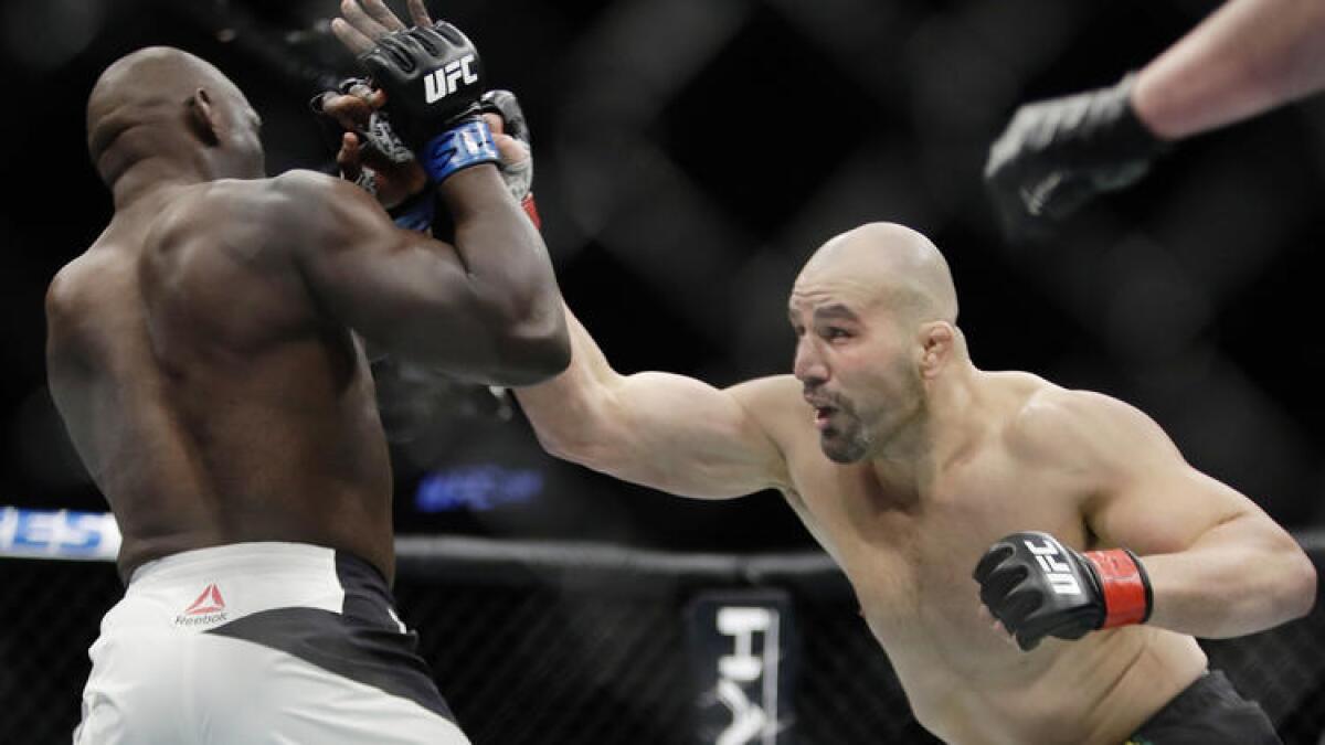 Jared Cannonier tries to block a punch by Glover Teixeira during their light-heavyweight bout at UFC 208.