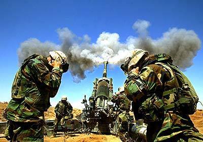 Members of the 1st battalion, 11th Marines, Alpha battery hold their ears as an artillery round from a 155mm Howitzer heads toward a destination in southern Iraq.