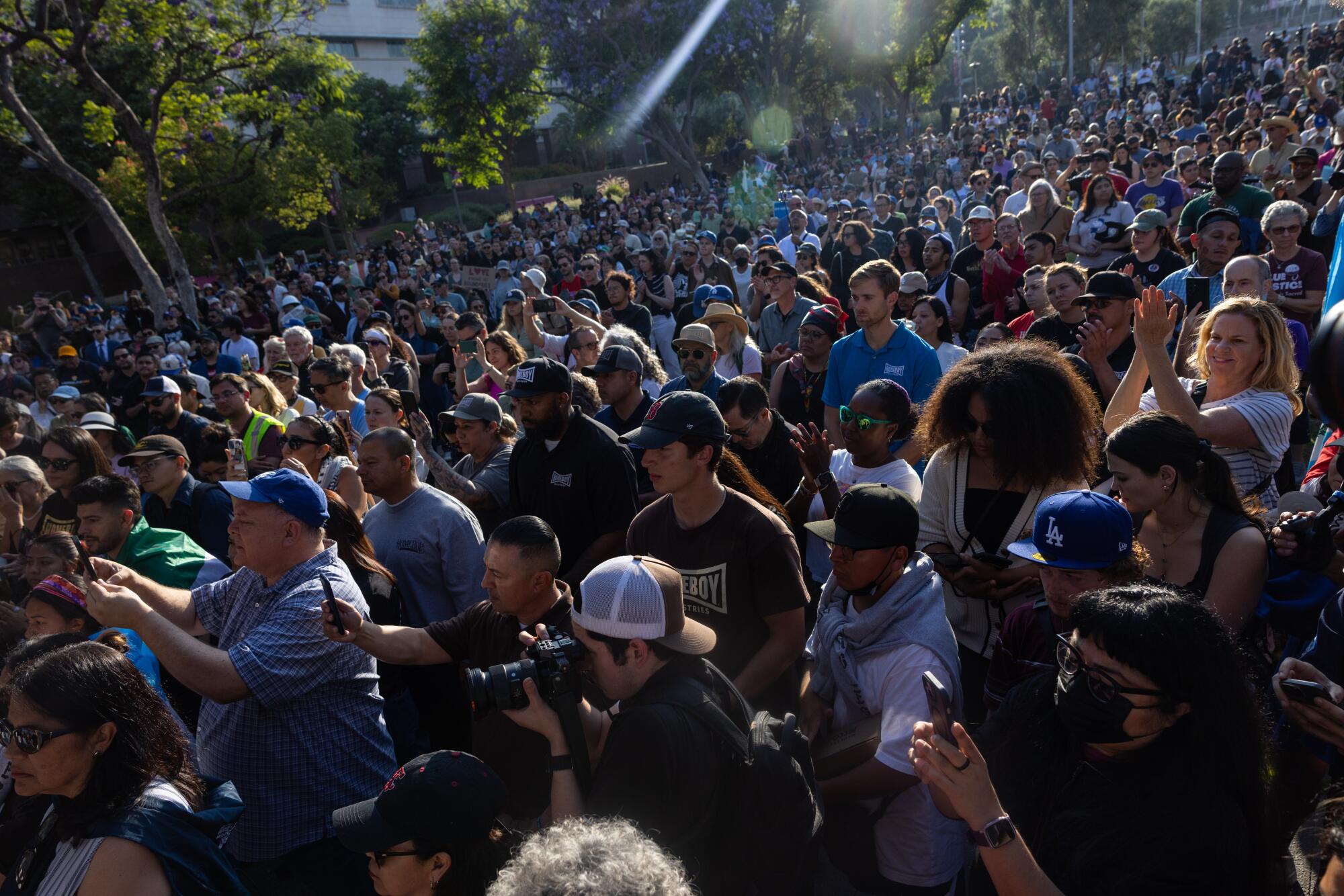 A large crowd gathers with faith leaders lead at a prayer vigil in Grand Park