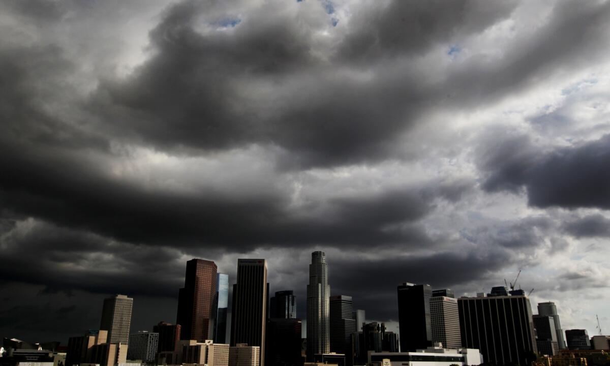 Storm clouds drift over downtown Los Angeles last year. The state reduced its water use again in November, but El Niño-related rainstorms have begun this month.