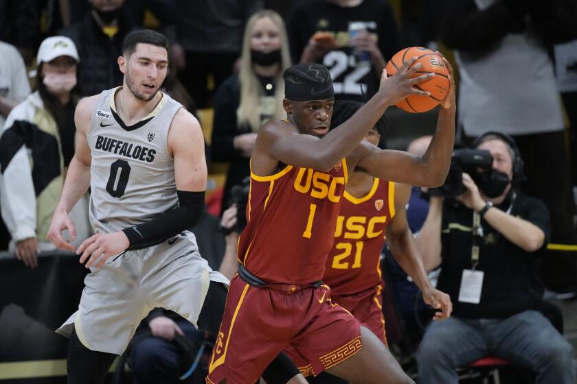 Southern California forward Chevez Goodwin, front, pulls in a loose ball as Colorado guard Luke O'Brien watches during the first half of an NCAA college basketball game Thursday, Jan. 20, 2022, in Boulder, Colo. (AP Photo/David Zalubowski)