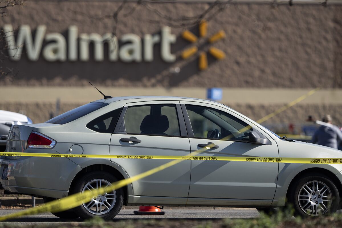 Una cinta para acordonar el sitio de un delito rodea un automóvil luego de un tiroteo a mansalva en una tienda Walmart