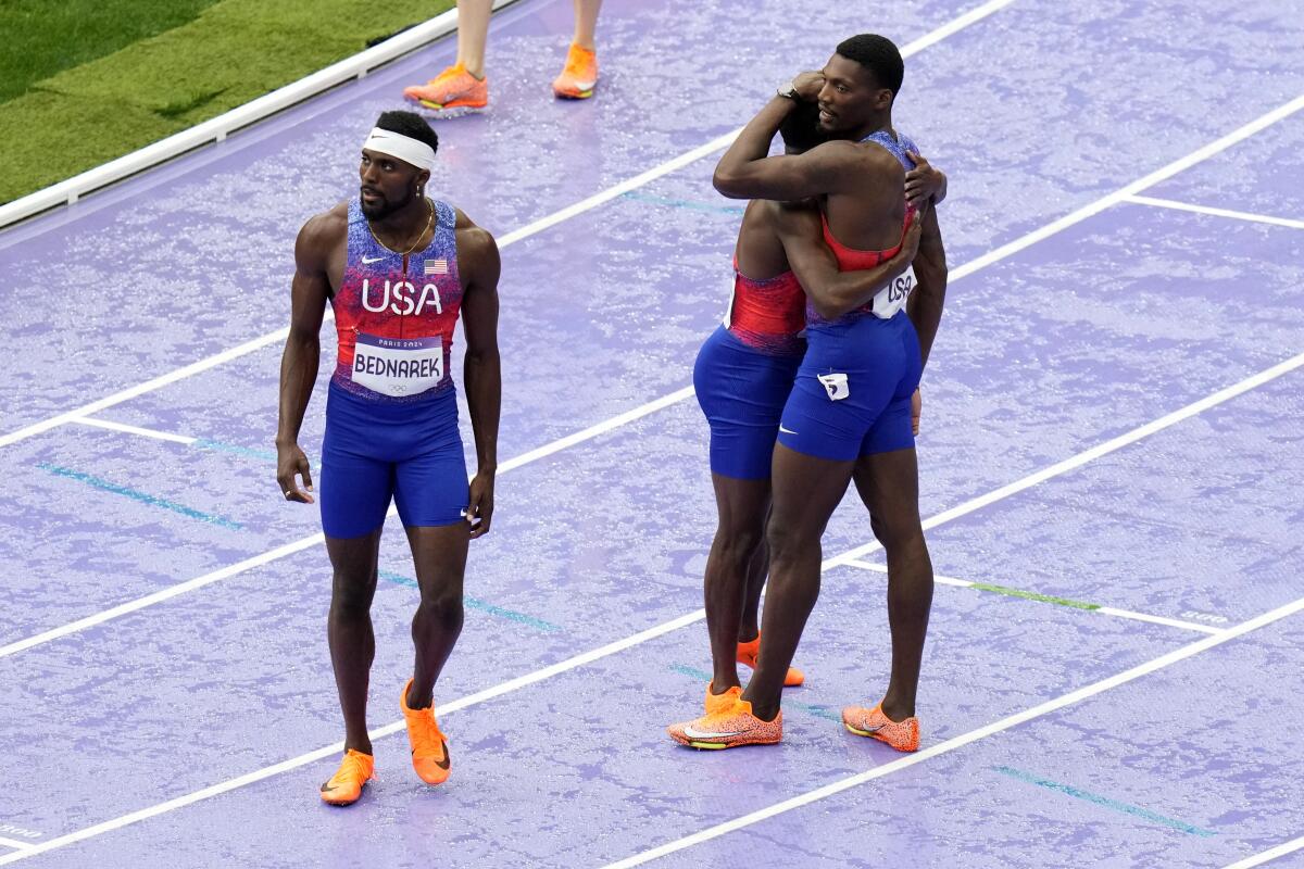 Members of the U.S. men's 400-meter relay team console each other after getting disqualified Friday during the Olympics.