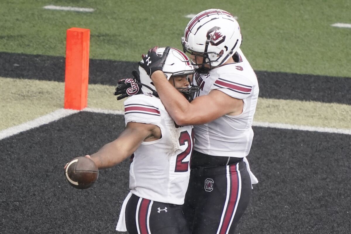 South Carolina running back Kevin Harris, left, is congratulated by tight end Nick Muse, right, after Harris scored a touchdown on a 25-yard run against Vanderbilt in the second half of an NCAA college football game Saturday, Oct. 10, 2020, in Nashville, Tenn. (AP Photo/Mark Humphrey)