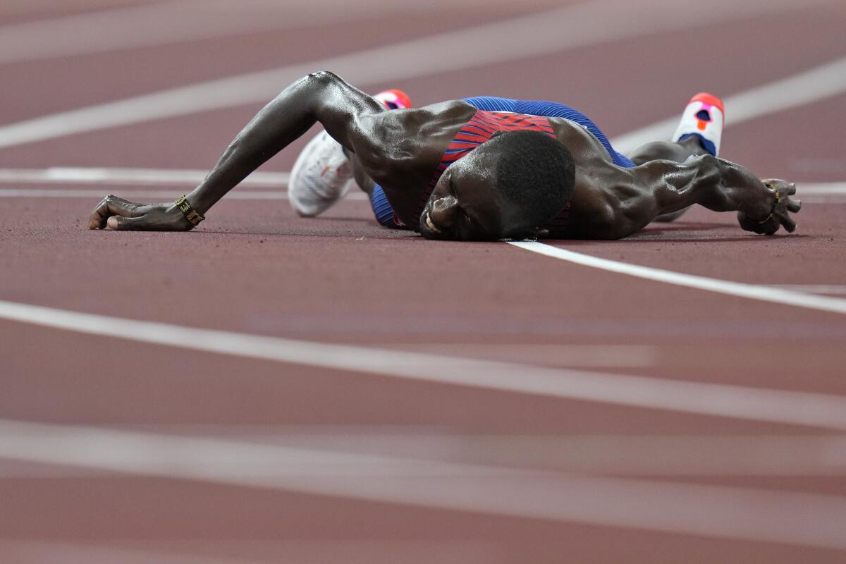 FILE - In this Aug. 6, 2021, file photo, Paul Chelimo, of United States, lies on the track after the final of the men's 5,000-meters at the 2020 Summer Olympics in Tokyo. (AP Photo/Petr David Josek, File)
