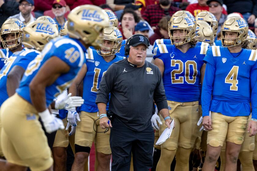 UCLA coach Chip Kelly reacts on the sidelines while standing alongside his players