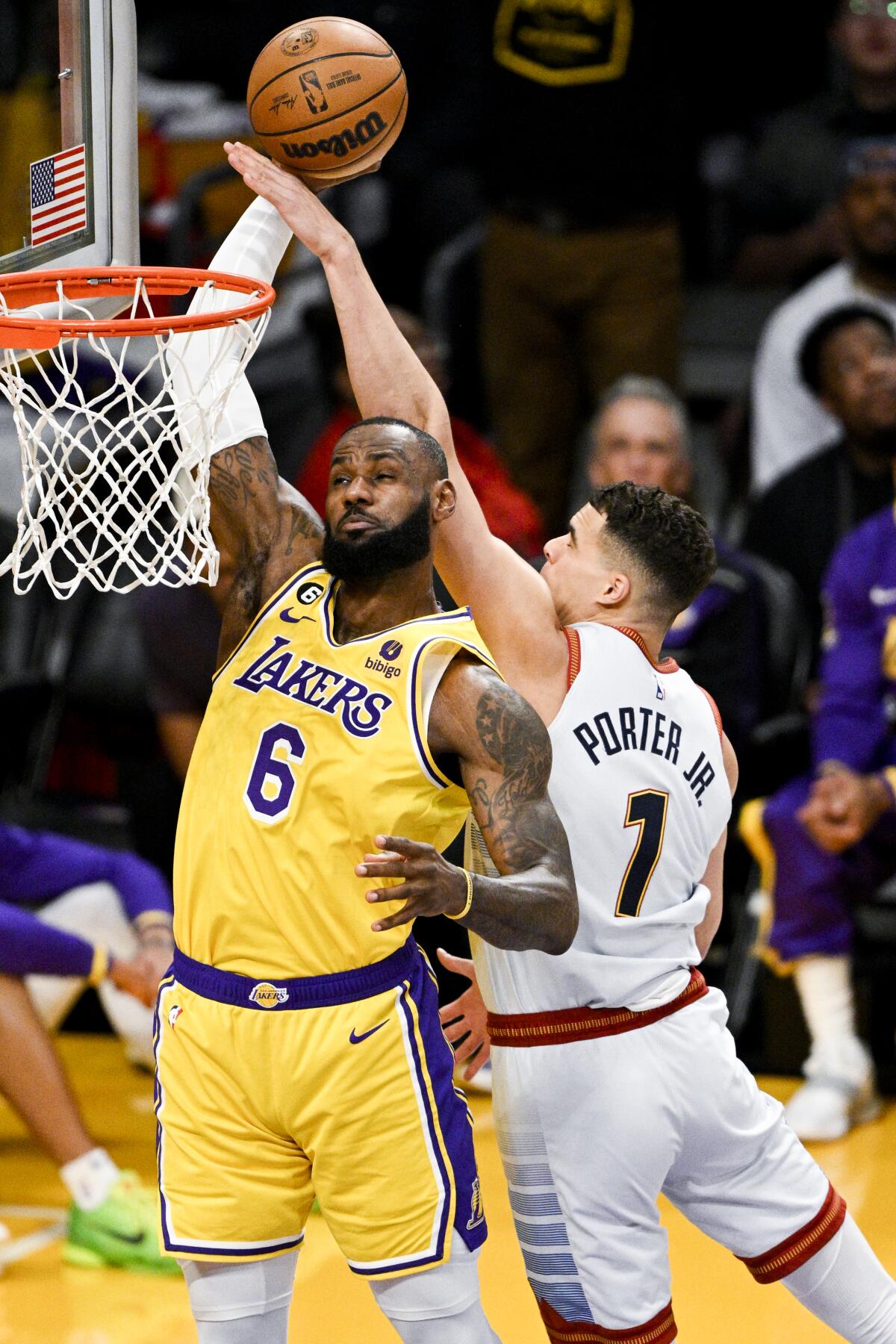 Lakers forward LeBron James, left, is fouled by Nuggets forward Michael Porter Jr. on a blocked dunk attempt.