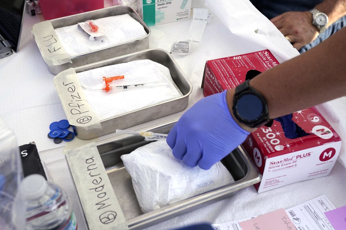 Syringes with vaccines are prepared at a free public clinic in Lynwood last year.