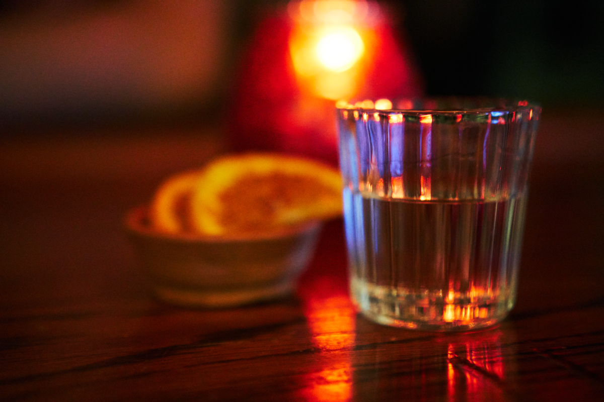 Shot glass with mezcal and orange slices on the side