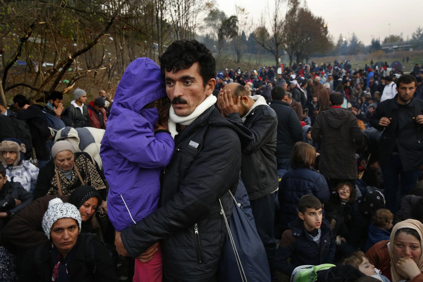 Omar Saman, of Iraq, holds his son Awyn, as he and his family wait to cross the border from Slovenia to Austria. Thousands of people push to get across the border into Austria from Slovenia where they were held up for days. Frustration is high as there is no food or water at this area between the two borders and no assistance for the thousands of families there.