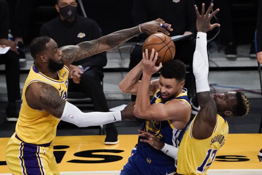 Los Angeles Lakers' LeBron James, left, and Dennis Schroder, right, defend against Golden State Warriors.