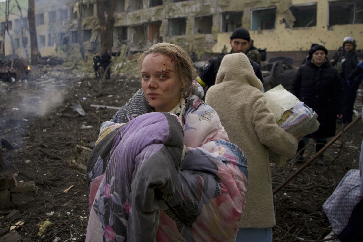 FILE - Marianna Vishegirskaya stands outside a maternity hospital that was damaged by shelling in Mariupol, Ukraine, Wednesday, March 9, 2022. Vishegirskaya, a Ukrainian beauty blogger who Russian officials accused of being a crisis actor when she was photographed in the rubble of a Mariupol maternity hospital a month earlier, has emerged in new videos that are fueling fresh misinformation about the attack. (AP Photo/Mstyslav Chernov, File)