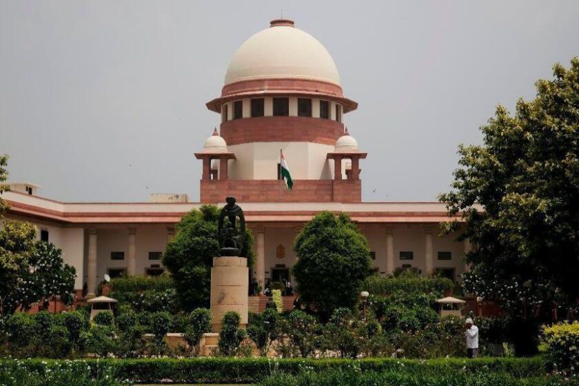 FILE - In this Aug. 22, 2017 file photo, a gardener works in the lawns of the Supreme Court in New Delhi, India. India's Chief Justice of the Supreme Court has presided over a string of verdicts in recent weeks that grant more rights to women, gay couples and religious minorities as he prepares to retire from the bench next month. (AP Photo/Altaf Qadri, File)