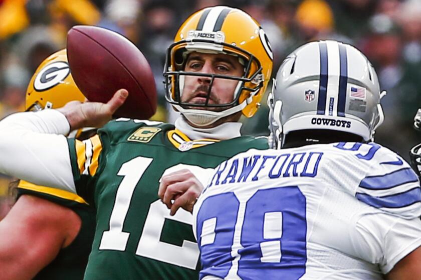 Green Bay Packers quarterback Aaron Rodgers passes under pressure from Dallas Cowboys defensive end Tyrone Crawford during the Packers' 26-21 victory in the NFC divisional playoffs Sunday.