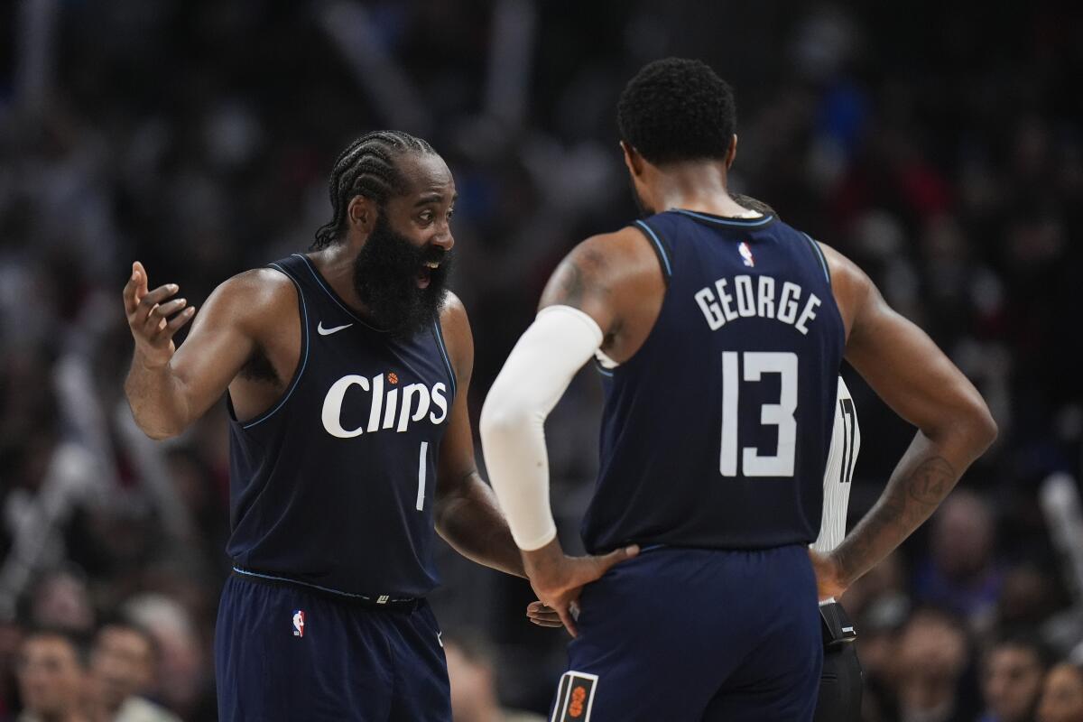 Clippers guard James Harden, left, and forward Paul George talk with a referee.