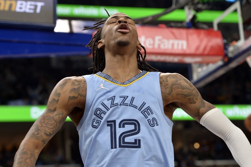 Memphis Grizzlies guard Ja Morant (12) reacts after scoring in the second half of an NBA basketball game against the Golden State Warriors, Tuesday, Jan. 11, 2022, in Memphis, Tenn. (AP Photo/Brandon Dill)