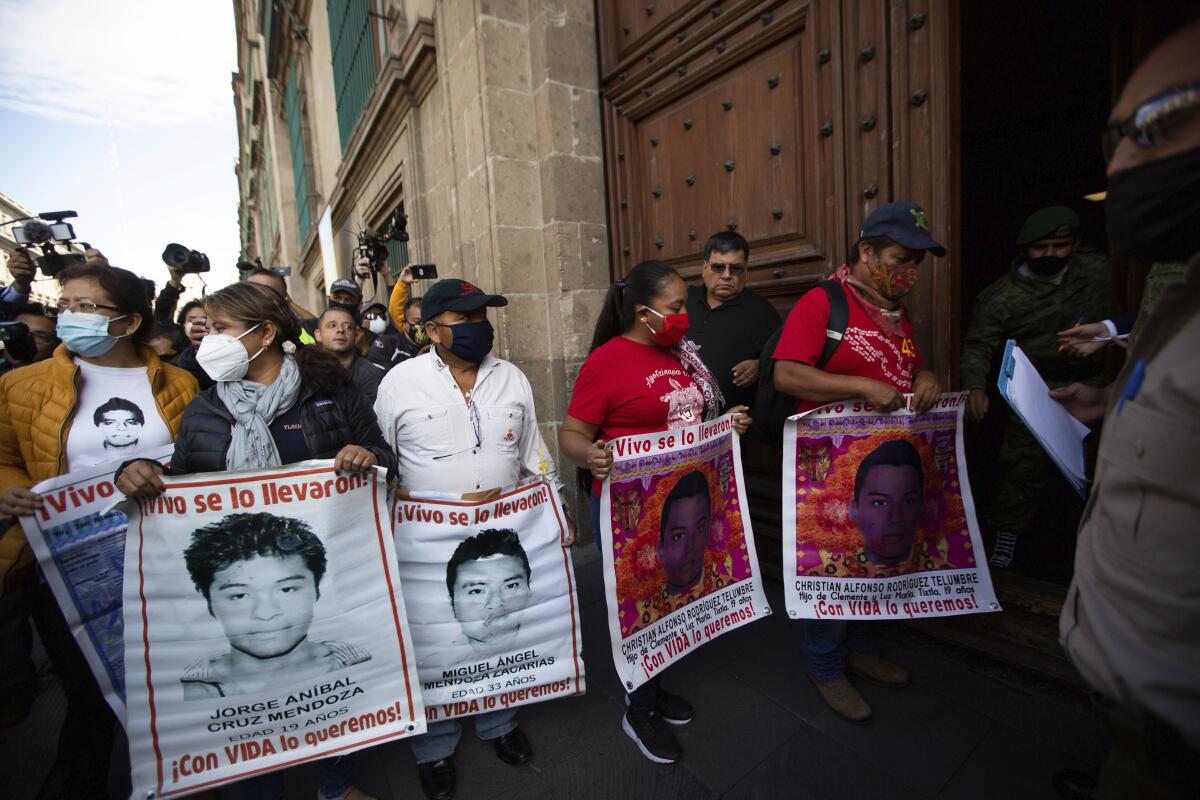 ARCHIVO - Padres con las fotos de sus hijos desaparecidos que son parte de los 43 estudiantes d