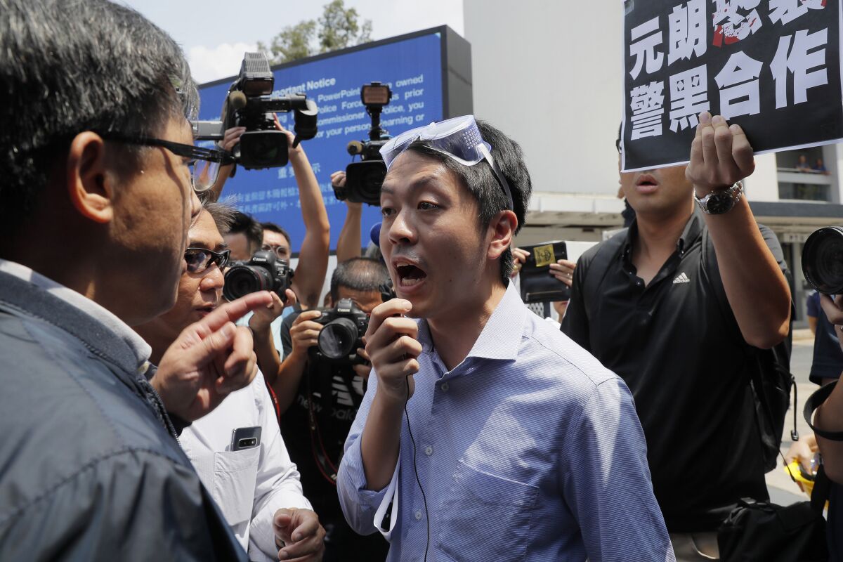 FILE - In this Aug. 12, 2019, file photo, pro-democracy lawmaker Ted Hui, center, argues with pro-Beijing lawmaker Junius Ho, left, during a demonstration in Hong Kong. Hui who is currently visiting Denmark urged European nations on Wednesday to allow protesters in Hong Kong "a safe haven from the terror” of China's Communist Party. (AP Photo/Kin Cheung, File)