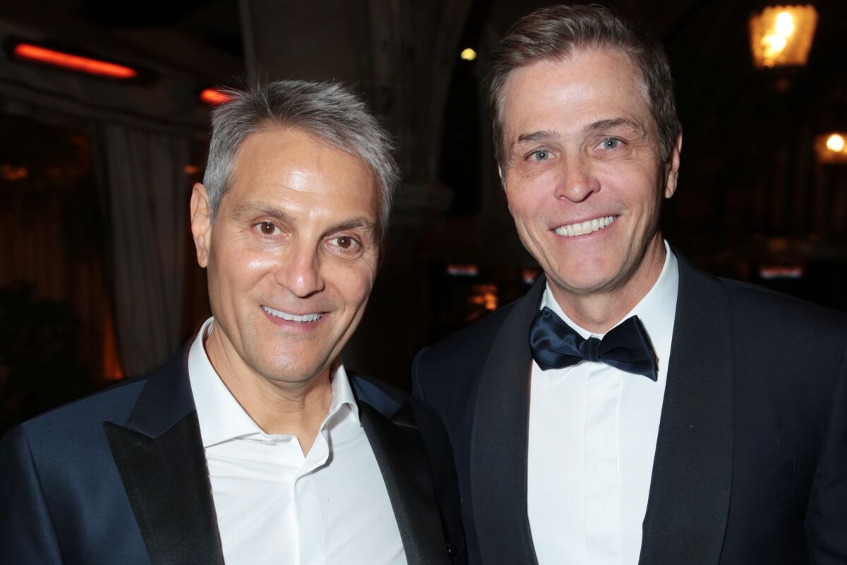 Two smiling men in tuxedos