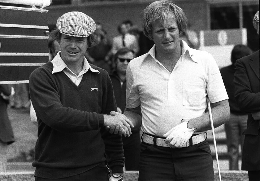 FILE - Tom Watson, left, of the U.S.A. and Jack Newton of Australia shake hands before the playoff to decide the winner of the British Open Golf Championship, in Carnoustie, Scotland in July 1975. Newton, who lost to Watson in a 1975 British Open playoff and tied for second behind Seve Ballesteros at the 1980 Masters before his professional golf career ended in a near-fatal plane propeller accident, has died Friday, April 15, 2022. He was 72. (AP Photo, File)