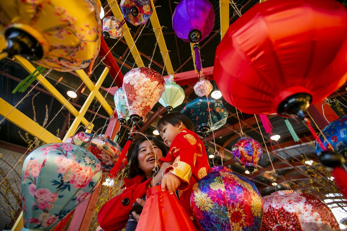 Ruy Gan and Demora Pham, 2, look at colorful lanterns.