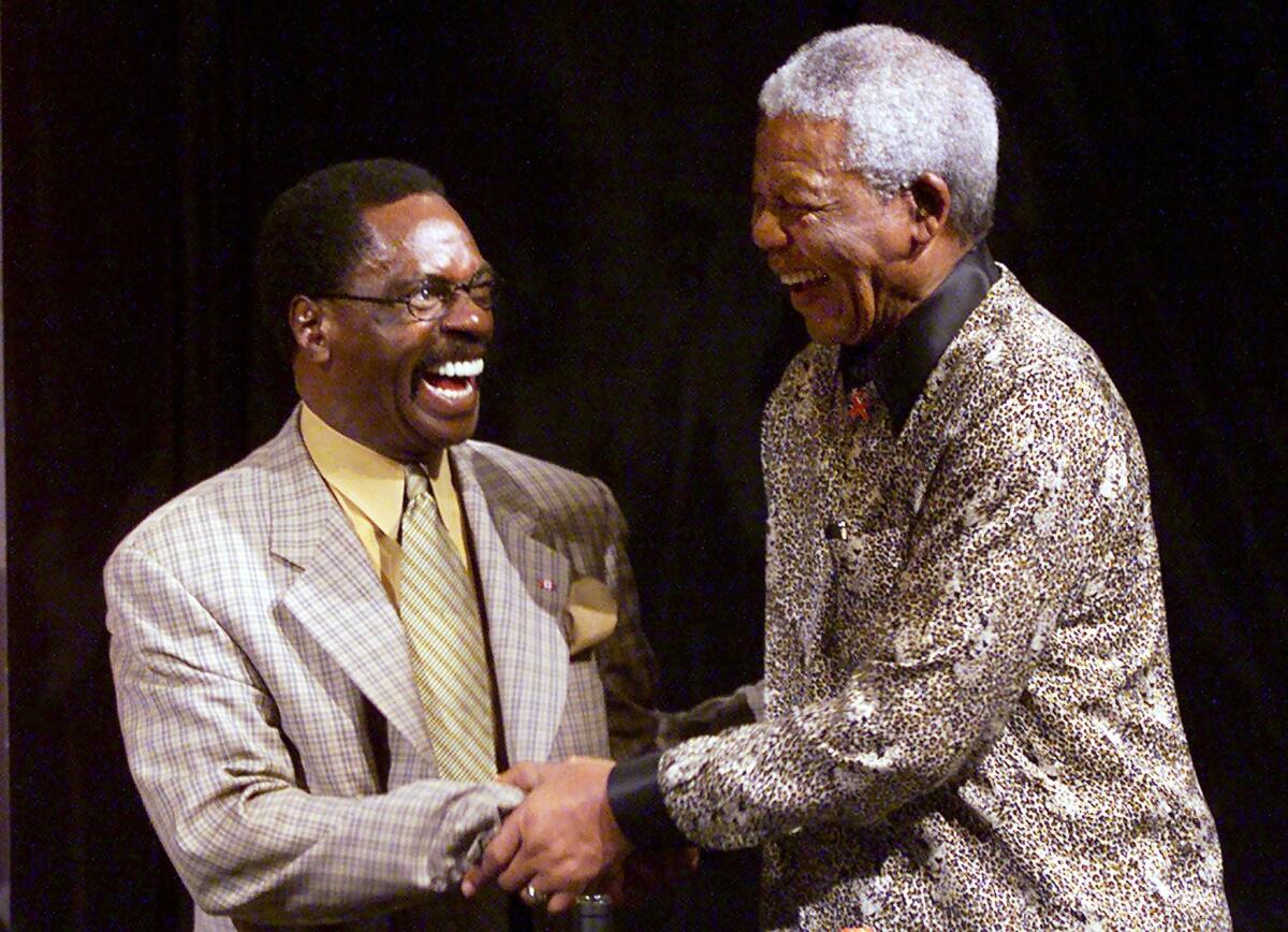 In a September 2000 file photo, Rubin "Hurricane" Carter, left, shakes hands with Nobel Peace laureate Nelson Mandela during inaugural World Reconciliation Day celebrations in Melbourne, Australia. Carter, who spent 19 years in prison for murder and was released after it was determined he did not get a fair trial, died Sunday at age 76.