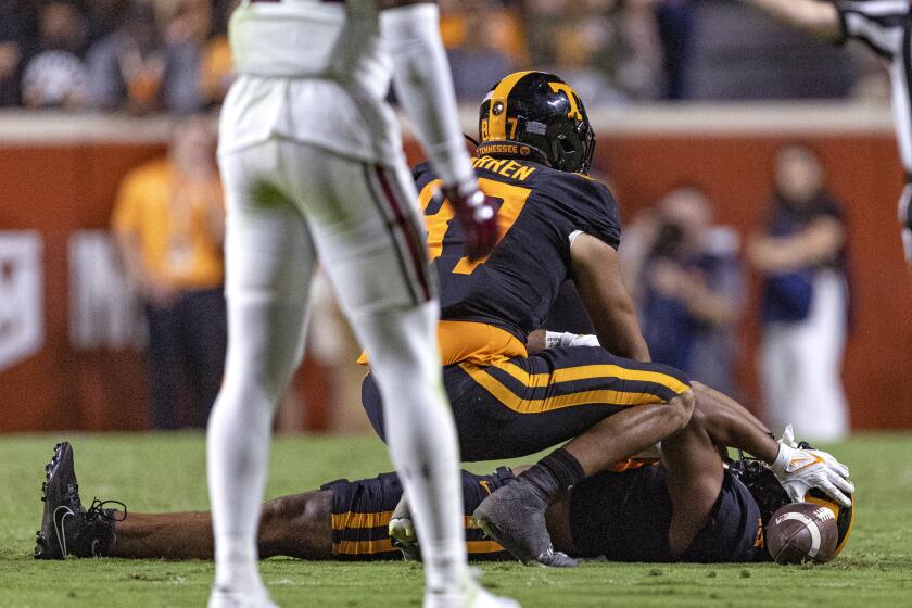 Tennessee wide receiver Bru McCoy (15) lies on the field after being injured, as tight end Jacob Warren (87) checks on him during the first half of the team's NCAA college football game against South Carolina on Saturday, Sept. 30, 2023, in Knoxville, Tenn. (AP Photo/Wade Payne)