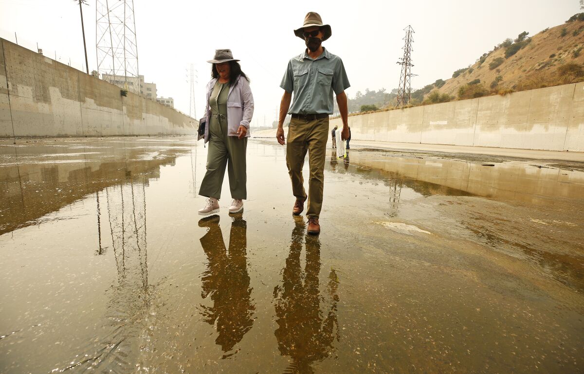 Two people standing in the concrete L.A. River bed