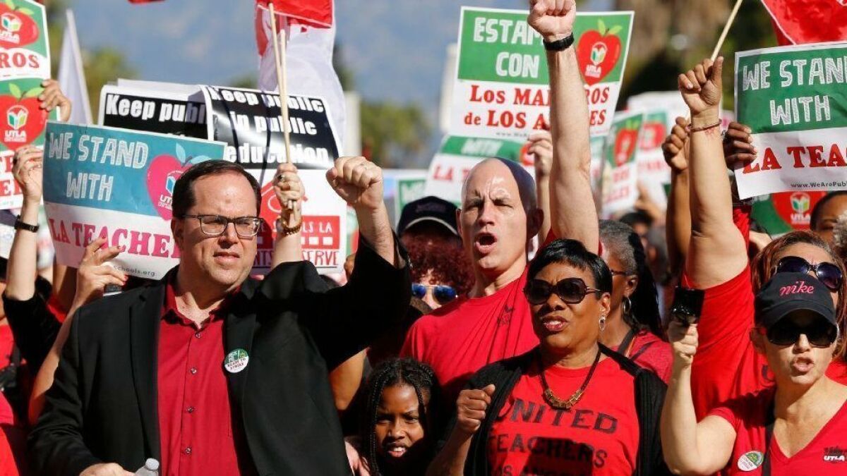 UTLA President Alex Caputo-Pearl, left, joins teachers in a rally in downtown Los Angeles on Dec. 15.