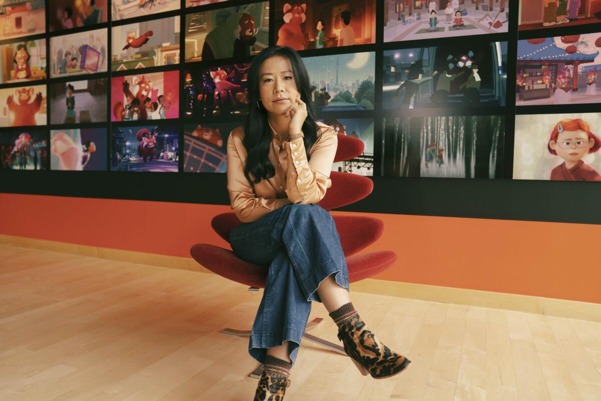 Director Domee Shi sits for a portrait in front of images of Pixar films.