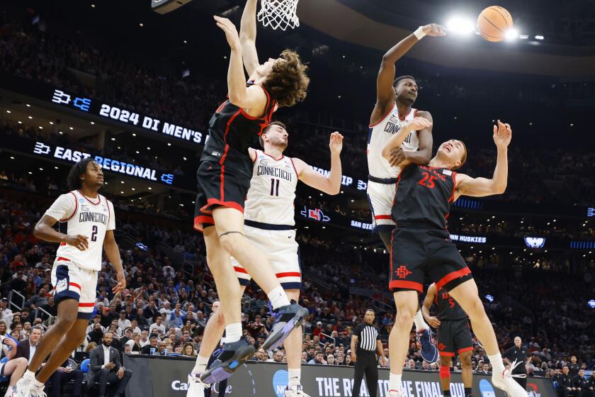 Boston, MA- March 28: UConn's Samson Johnson hits the ball away above San Diego State's Elijah Saunders during a NCAA Tournament Sweet 16 game at the TD Garden on Wednesday, March 28, 2024 in Boston, MA. (K.C. Alfred / The San Diego Union-