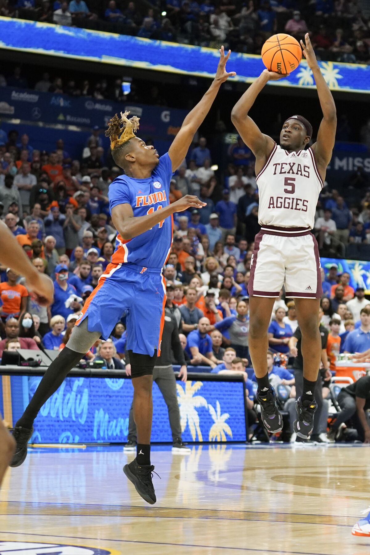 Texas A&M guard Hassan Diarra (5) makes the game-winning shot over Florida guard Kowacie Reeves (14) during overtime of an NCAA college basketball game at the Southeastern Conference tournament in Tampa, Fla., Thursday, March 10, 2022. (AP Photo/Chris O'Meara)