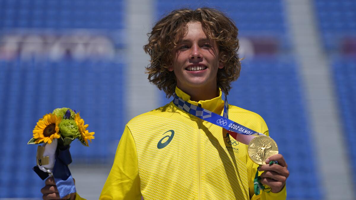 Keegan Palmer of Australia smiles and holds his gold medal at the Tokyo Olympics.